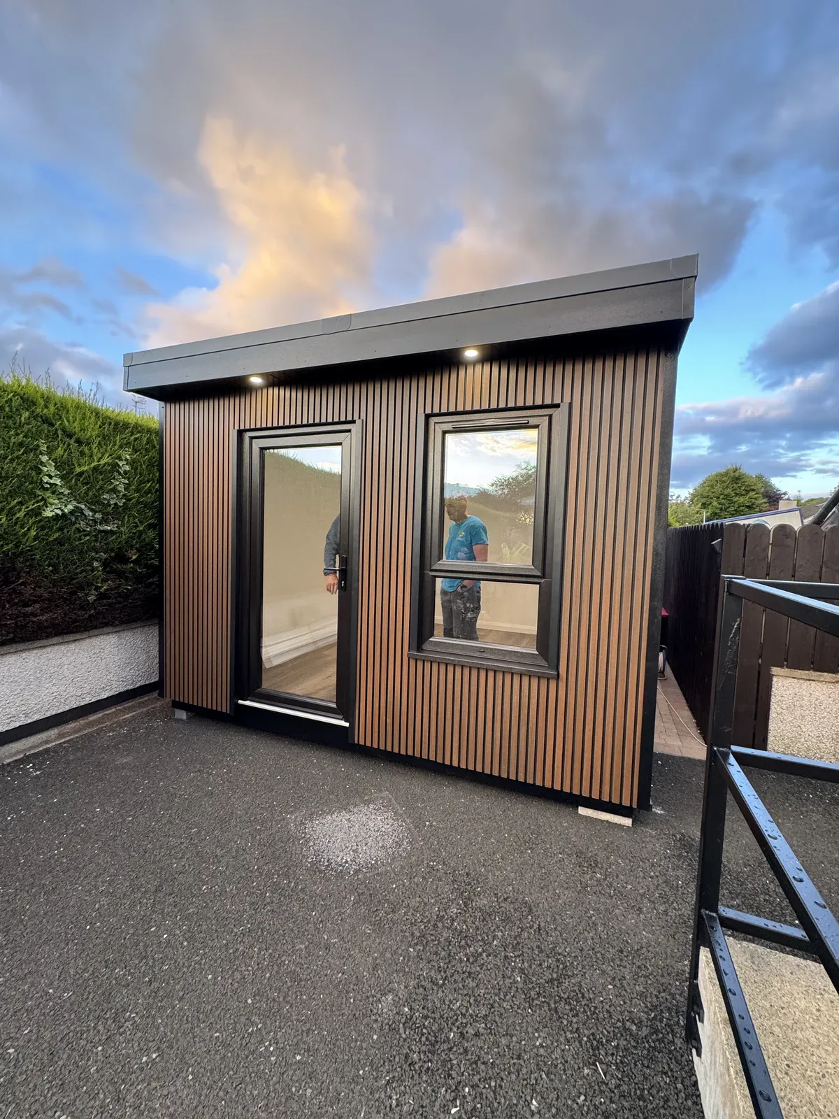 Timber-clad garden room with black windows and downlights